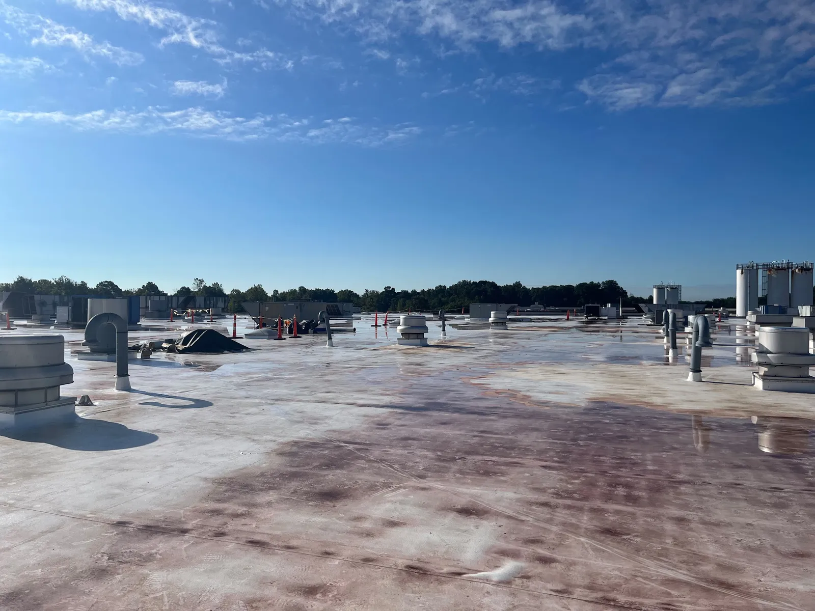 Flat commercial roof mid-way through a coating application
