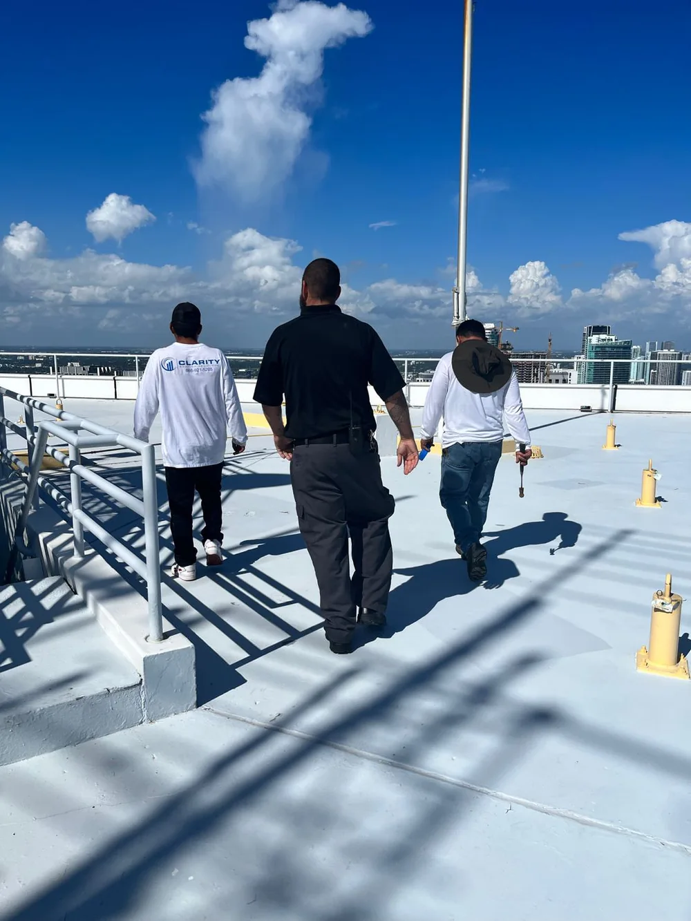 Clarity Roofing team walking on a South Florida commercial flat roof